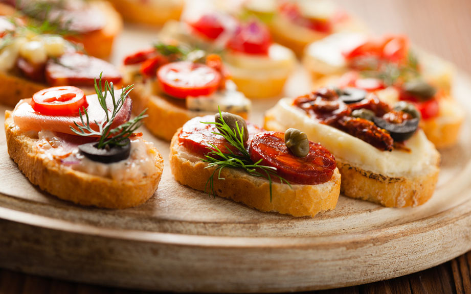 some-food-is-on-a-white-plate-and-sits-on-a-wooden-table-next-to-an